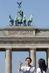 Asiatische Touristen vor dem Brandenburger Tor in Berlin