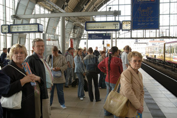 Menschen warten auf verspaeteten Zug