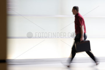 Mann mit Aktenkoffer eilt zum Ausgang