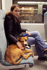 Maedchen mit Hund in der S-Bahn in Berlin
