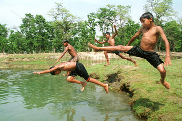 Kinder springen in einen Fluss in Nepal