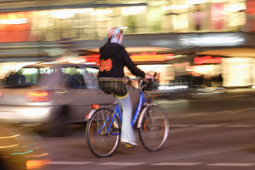 Fahrradfahrerin im abendlichen Strassenverkehr