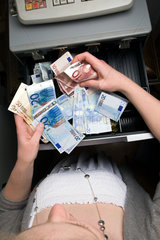 Berlin  Deutschland  eine Angestellte zaehlt das Geld in der Registrierkasse