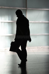 Silhouette eines Mannes mit Aktentasche und haengendem Kopf