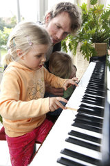Hamburg  Deutschland  Vater und Kinder spielen Klavier