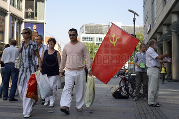 Passanten und Mann mit ehemaliger Flagge der Sowjetunion in Dresden
