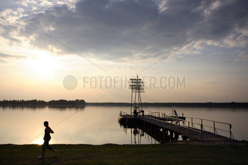Silhouette einer Frau und Abendhimmel am Wandlitzsee in Brandenburg