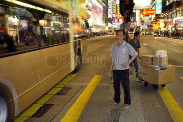Mann wartet auf einer Strasse im Stadtteil Kowloon in Hongkong