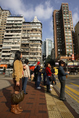 Passanten warten an einer Ampel im Stadtteil Kowloon in Hongkong