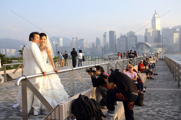 Fotografen fotografieren ein Hochzeitspaar auf dem Kowloon Pier in Hongkong