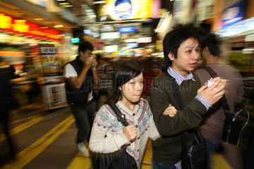 Menschen in einer Geschaeftsstrasse im Stadtteil Kowloon in Hongkong