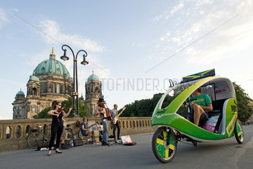 Berlin  Deutschland  ein Velotaxi auf der Friedrichsbruecke vor dem Berliner Dom