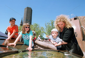 Touristen am Wasser des Weltkugelbrunnens in Berlin