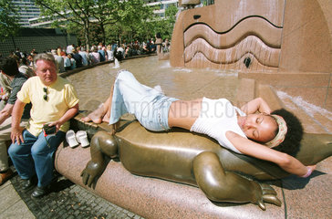 Frau sonnt sich am Weltkugelbrunnen in Berlin