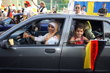 Fussballfans WM 2006: Mutter mit Kopftuch und Sohn mit deutscher Fahne im Auto
