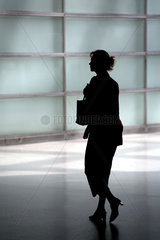 Silhouette einer Frau  ihre Tasche fest im Griff