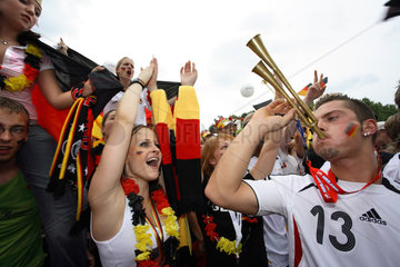 Berlin  Fussballfans WM 2006: Anfeuernde Maenner und Frauen und Deutschlandfahnen