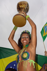 Fussballfans WM 2006: Brasilianerin mit Nationalfahne haelt Pokal aus Gummi