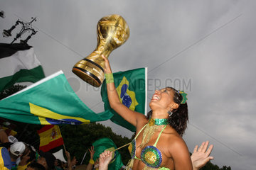 Fussballfans WM 2006: Brasilianerin mit Nationalfahne haelt Pokal aus Gummi