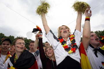 Berlin  deutsche Fussballfans WM 2006: Frau jubelnd zwischen Maennern