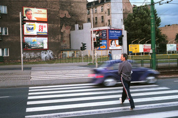 Mann ueberquert einen Zebrastreifen in Poznan  Polen