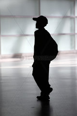 Silhouette eines Jungen mit Baseballkappe und Rucksack