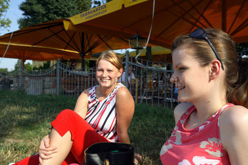 Junge Frauen sitzen auf den Elbwiesen in Dresden