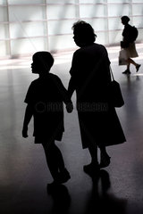Silhouette einer Grossmutter mit ihrem Enkelkind an der Hand