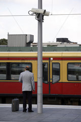 Fahrgast und Zug am Bahnsteig mit Videoueberwachung im Hauptbahnhof in Berlin