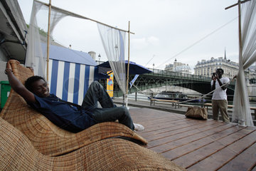 Student entspannt auf einem Liegestuhl am Ufer der Seine in Paris