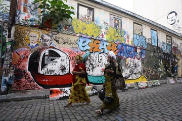 Frauen vor einer Hauswand mit Graffiti im Viertel Belleville in Paris