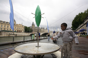 Junge spielt an einem Springbrunnen an der Seine in Paris