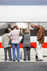 Menschen winken am Fenster eines Zuges zum Abschied