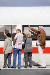Menschen winken am Fenster eines Zuges zum Abschied
