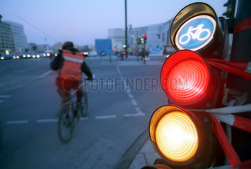 Rotgelbe Ampel und Fahrradkurier auf der Strasse