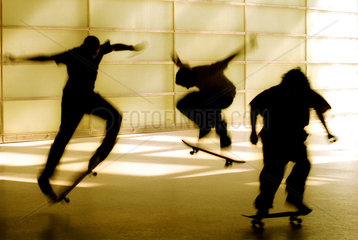 Silhouetten von drei Jugendlichen auf dem Skateboard