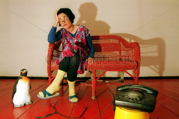 Eine Frau sitzt  wartend auf einen Anruf  beim Telefon