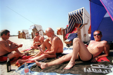 Karten spielende u. sich sonnende Herren am Strand der Ostsee