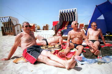Sich sonnende Herren am Strand der Ostsee