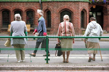 Vier Seniorinnen an einer Bushaltestelle