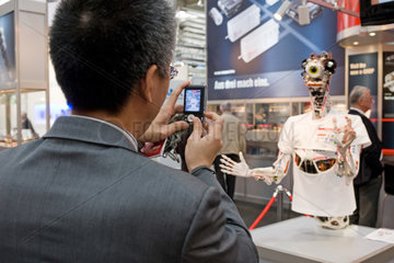 Hannover  Deutschland  ein asiatischer Geschaeftsmann fotografiert einen Roboter