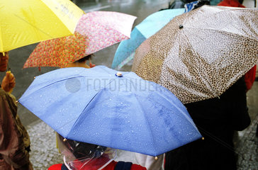 Menschen unter Regenschirmen in Berlin