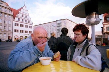 Ein Paar loeffelt Suppe auf dem Marktplatz in Leipzig