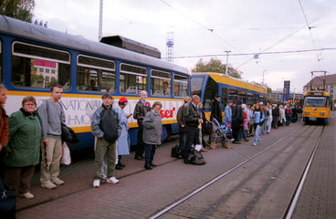 Menschen warten auf die Strassenbahn in Leipzig