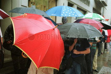 Menschen unter Regenschirmen in Berlin