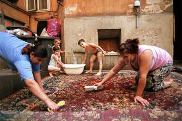 Familie waescht Teppich in einem Berliner Hinterhof