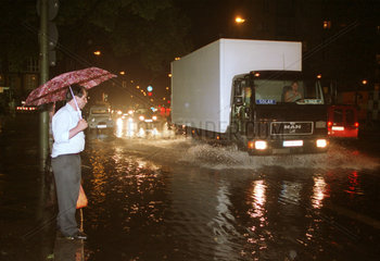Mann und LKW in einer ueberfluteten Strasse in Berlin
