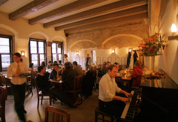 Gaeste und Klavierspieler in einem Gasthaus in Leipzig