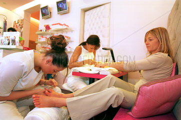 Kosmetiksalon: Frau laesst sich die Naegel manikueren
