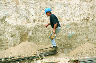 Bauarbeiter balanciert ueber Stahlstangen